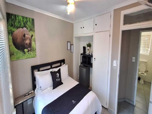 a bedroom with a bed and a picture of a cow at Jukskei Big5 - Rhino in Fourways