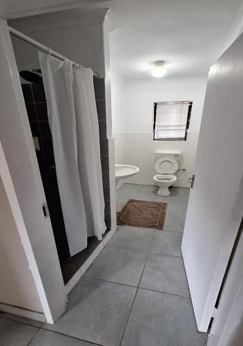 a bathroom with a toilet and white towels at Jukskei Big5 - Rhino in Fourways