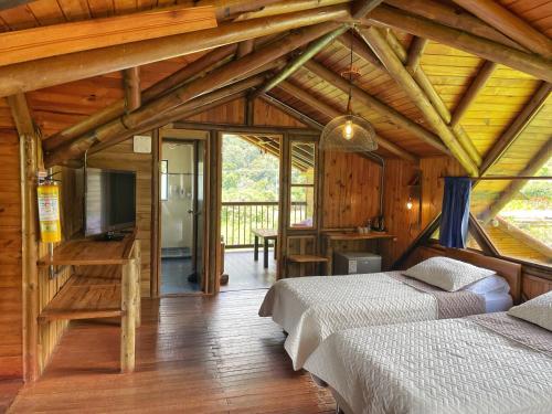 a bedroom with two beds in a wooden house at Palmas de Cocora in Salento