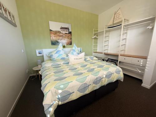 a bedroom with a bed with blue pillows on it at das Ferienhaus Auszeit in Kranenburg