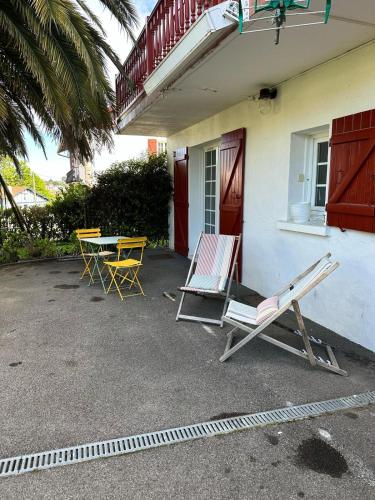 two chairs and a table in front of a house at chambre avec terrasse et coin repas in Ciboure
