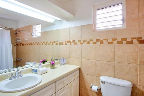 a bathroom with a sink and a toilet and a mirror at 3BR Beachfront Villa w/ Staff-DRMNV in Duncans