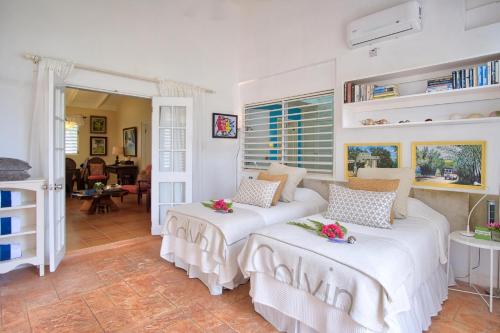 a bedroom with two beds and a living room at 3BR Beachfront Villa w/ Staff-DRMNV in Duncans