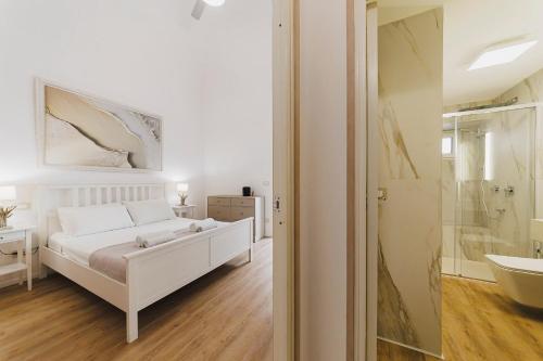 a white bedroom with a bed and a bathroom at Best view Giovinazzo in Giovinazzo