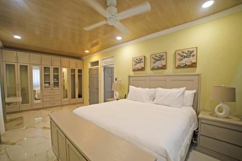 a bedroom with a large white bed and a ceiling at 3BR Modern Villa w/ Private Pool & Fire Pit in Saint Philip