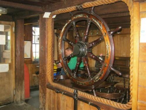a large wooden wheel in a wooden room at The Ship Inn in St Austell