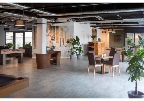 an office with a table and chairs and plants at Brera Stuttgart in Stuttgart
