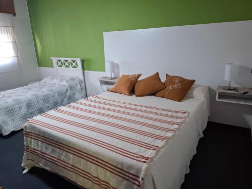 a bedroom with a bed with pillows on it at Alojamiento Passiflora I in Villa Elisa