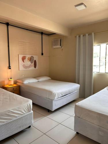 a bedroom with two beds and a window at Pousada Rota do Parque in Penha