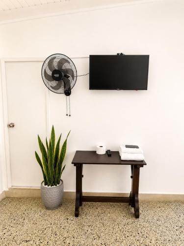 a room with a table and a fan on a wall at Absolute Nova Hotel in Medellín