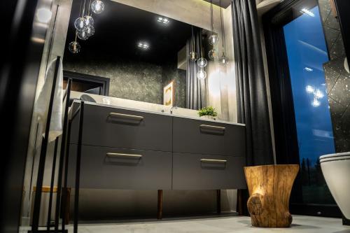 a bathroom with a vanity with a sink and a mirror at Dom w czerni in Górniki