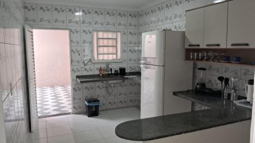 a kitchen with a white refrigerator and a window at Casa IBM - Crato in Crato