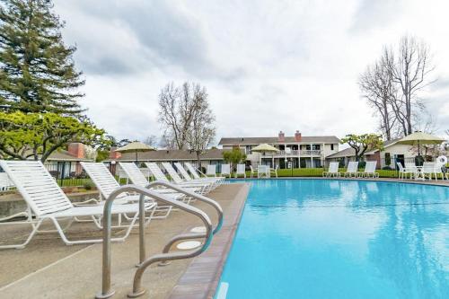 a swimming pool with white lounge chairs in a resort at Silverado Resort and Spa 354 in Napa