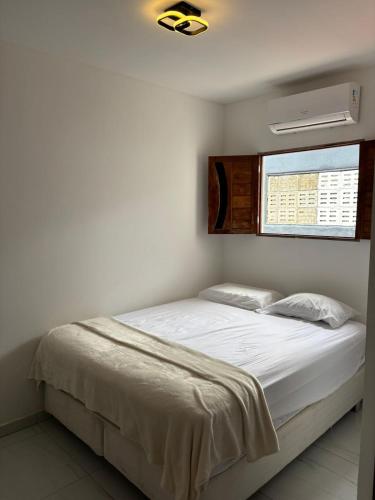 a bedroom with a white bed with a window at Hotel pousada czar in João Pessoa