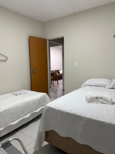 a bedroom with two beds and a door to a living room at Casa IBM - Crato in Crato