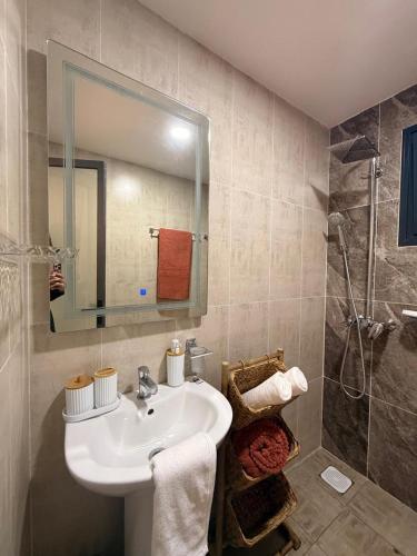 a bathroom with a sink and a shower at Cocon de paix à Ngor Virage in Dakar
