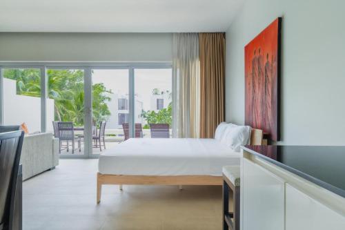 a bedroom with a bed and a balcony at NEW Serenity Tropical 2 Bed Condo On Beachfront in Ban Saiyuan (1)