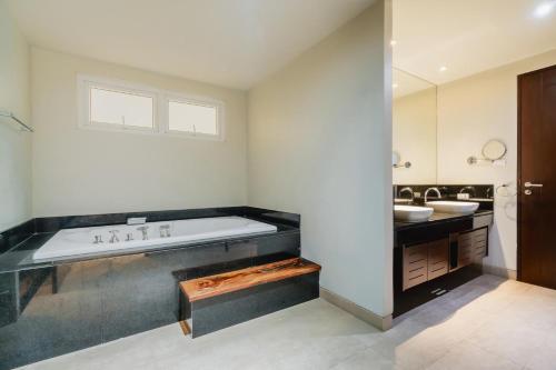 a bathroom with a large tub and a sink at NEW Serenity Tropical 2 Bed Condo On Beachfront in Ban Saiyuan (1)
