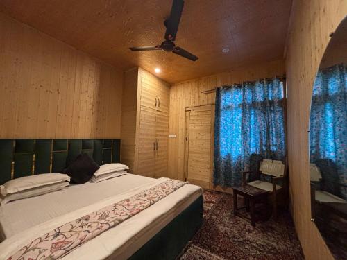 a bedroom with a large bed and a ceiling fan at Favela Headrooms in Srinagar