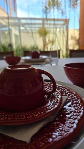 a cup of coffee sitting on a plate on a table at Refúgio in Ouro Preto