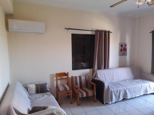 a room with a bed and a couch and a chair at Real Apartment Αληθινή Διαμονή in Diakopto