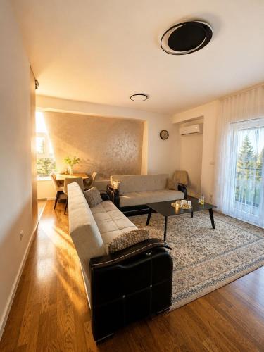 a living room with a couch and a table at Trebevic Skyline Apartman in Dovlići