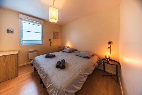 a bedroom with a large bed with two bags on it at Terrasse de l'aber Roscoff in Roscoff