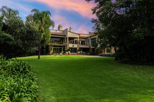 a large house with a green lawn in front of it at Hagios House in Pretoria