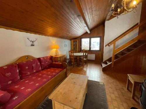 a living room with a red couch and a table at Chalet Maria in Samoëns