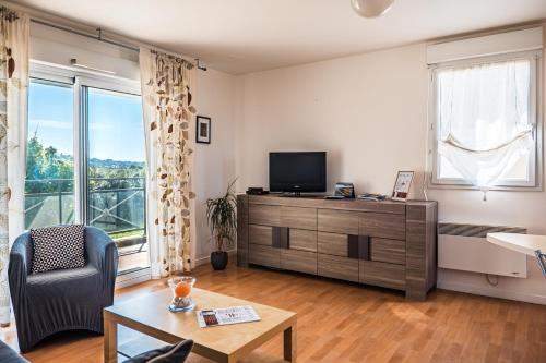 a living room with a tv and a couch and a table at Terrasse de l'aber Roscoff in Roscoff