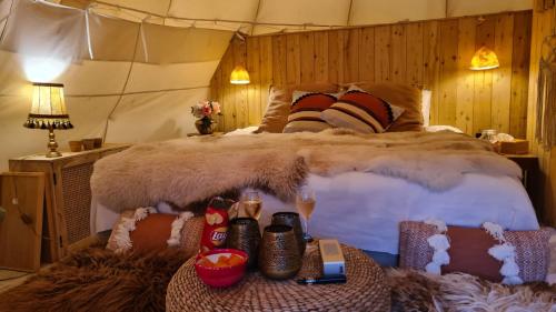 a bedroom with a large bed and a table with shoes at Tipi Marie at Logie Marie in Kaprijke
