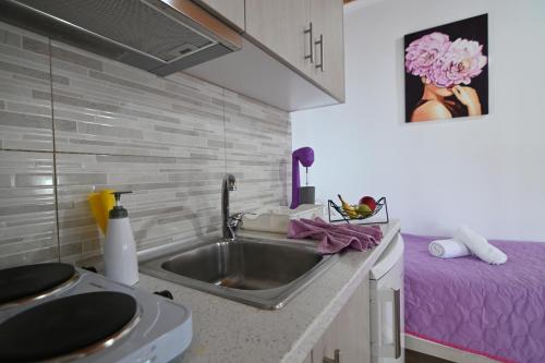 a kitchen with a sink and a purple bed at Villa Evelin in Asprovalta