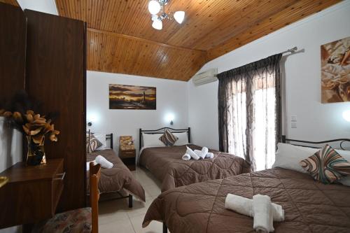 a bedroom with two beds and a wooden ceiling at Villa Evelin in Asprovalta