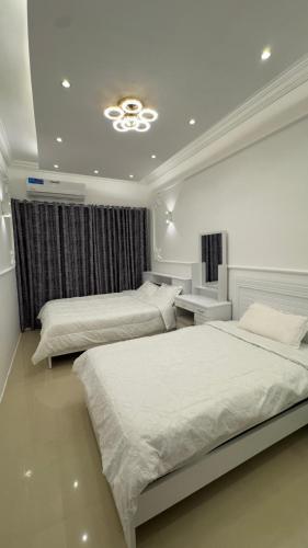 a bedroom with two beds and a ceiling at كورنيش عجمان in Ajman 
