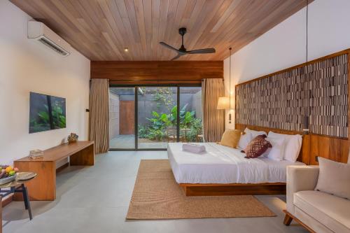 a bedroom with a bed and a desk and a couch at Cascara Resort Weligama - A Tropical Sanctuary in Weligama