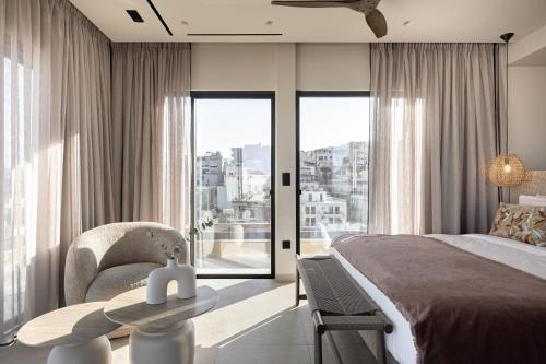 a bedroom with a bed and a table with a chair at MonCasa suites in Agios Nikolaos