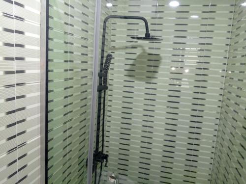 a shower in a bathroom with blinds on a window at Lovely surulere apartment in Lagos