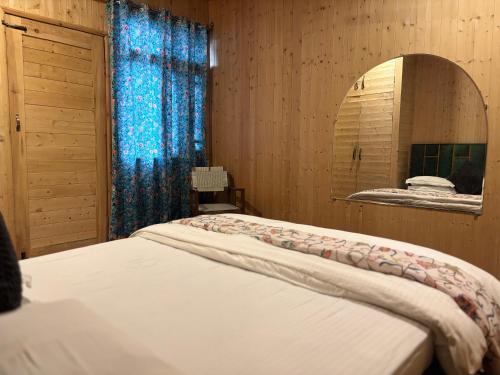 a bedroom with two beds and a mirror at Favela Headrooms in Srinagar