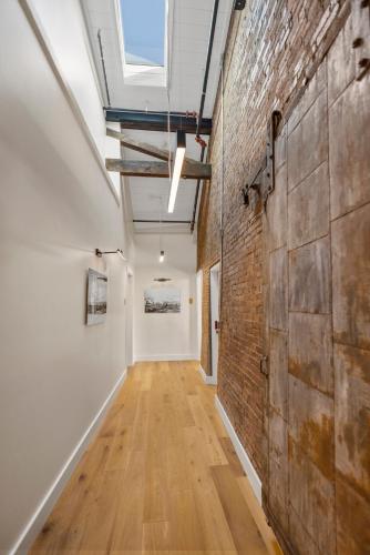 an empty hallway with a brick wall and a window at The Evalina Hotel in Portland