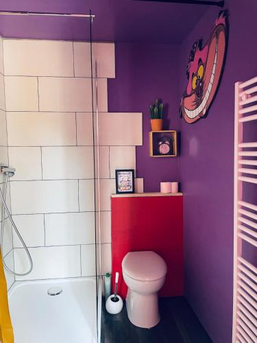 a purple bathroom with a toilet and a tub at La Berlingote in Cherbourg en Cotentin