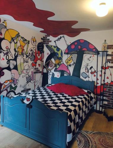 a bedroom with a wall covered in cartoon characters at La Berlingote in Cherbourg en Cotentin