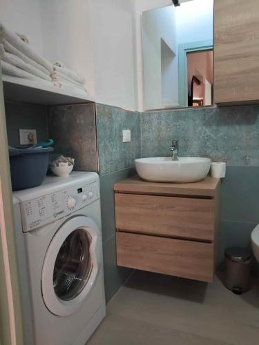 a bathroom with a washing machine and a sink at Casa Peppo in Marciana