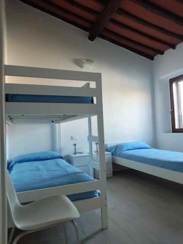 a bedroom with two bunk beds and a chair at Casa Peppo in Marciana