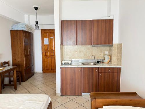 a kitchen with wooden cabinets and a sink at Vythos Rooms in Paralio Astros