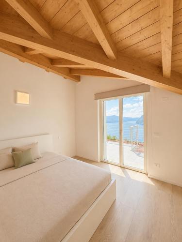 a bedroom with a bed and a large window at Iseo Collection in Riva di Solto
