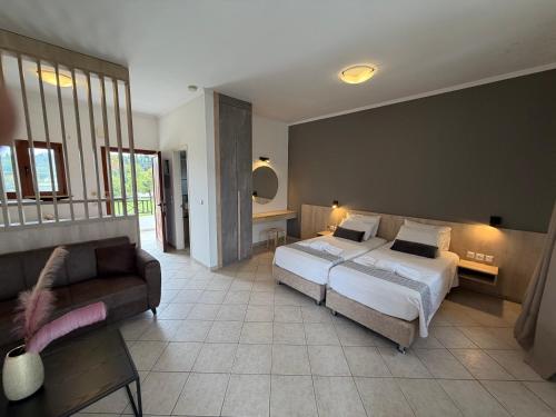 a bedroom with a bed and a couch at Stemma Hotel in Sidari