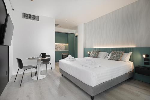 a bedroom with a large white bed and a table at Palatium Riccione Suite in Riccione