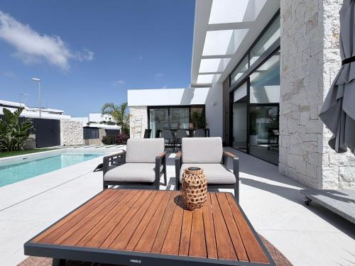 a patio with two chairs and a wooden table at L'au D'evi in Rojales