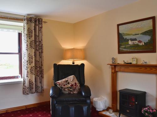 a living room with a chair and a window at Port-An-Eillean in Feorlean