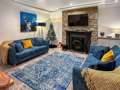 a living room with blue couches and a christmas tree at The Alnwick Townhouse in Alnwick